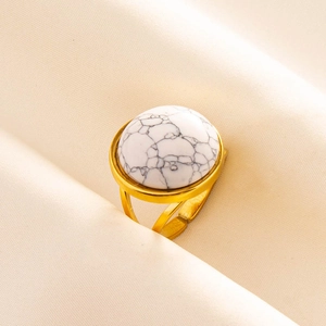 Macro view of a gold adjustable ring featuring a round white stone with natural textures