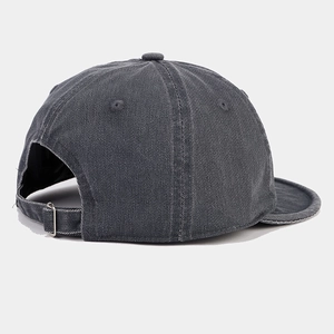 Detail of adjustable metal buckle and washed denim texture on a dark grey baseball cap