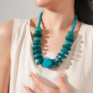 Close-up of a turquoise wood beaded necklace with a geometric multifaceted pendant for women