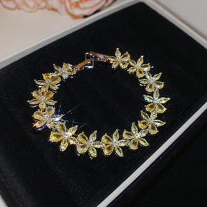 Detail of flower bracelet with yellow zircon petals on a black velvet jewelry box