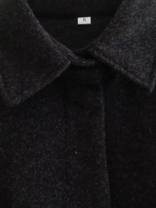 Gros plan détaillé du col et de la texture de ce manteau en laine noir en taille S