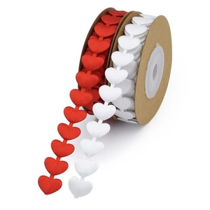 Detailed view of red and white heart-shaped ribbon rolls for Valentine gift wrapping
