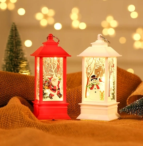 Detail of Santa Claus and Snowman LED lanterns on rustic burlap with warm festive lighting