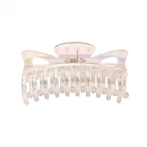 Detailed macro shot of large iridescent hair claw clip with colorful pearlescent finish