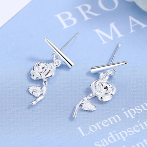 Minimalist silver rose flower earrings with sleek bar pendant on a blue background