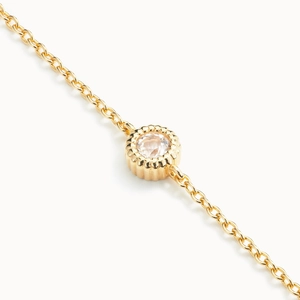 Macro shot of gold S925 silver bracelet featuring a sparkling round bezel-set diamond charm