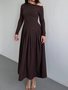 Détail d'une élégante robe maxi marron foncé à épaules dénudées avec manches longues et jupe plissée