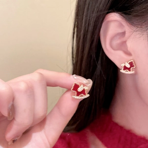 Detail of 18K gold plated horse stud earrings with red enamel and sparkling zircons