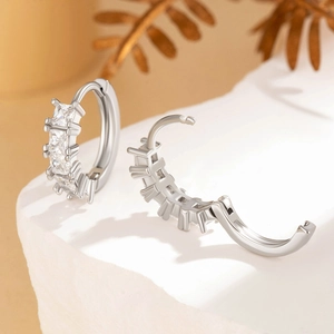 Silver square zircon hoop earrings showing open and closed positions on a stone base