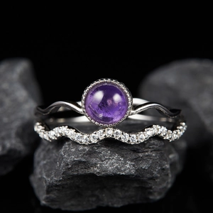 Close-up of S925 silver ring set with natural purple gemstone on dark textured stone