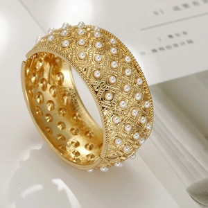 Gold plated cuff bracelet with pearl inlay and openwork lattice vintage design