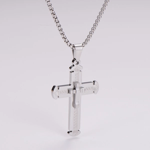 Detailed macro view of silver stainless steel cross pendant with Greek key pattern