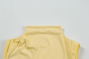 Detail shot of pale yellow mock neck top showing high-quality fabric and stitching