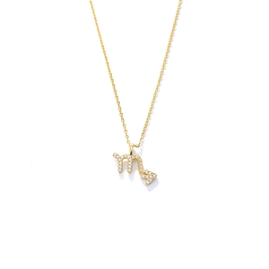 Macro shot of Scorpio zodiac pendant necklace with clear crystals in golden finish
