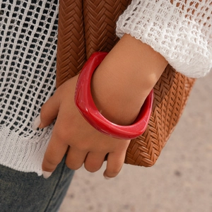 Chic red resin chunky bracelet shown on model with stylish knitted top and woven bag