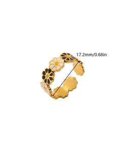 Macro detail of enamel daisy flower ring featuring white petals and golden band
