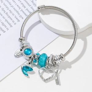 Detailed view of silver charm bracelet with blue glass beads and heart pendants