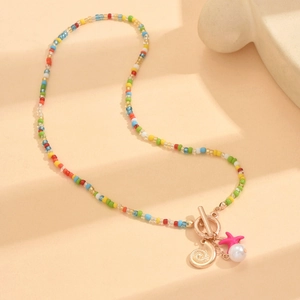 Colorful seed bead necklace with shell starfish and pearl charms on beige surface