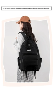 Dettaglio dello zaino scolastico nero in nylon resistente con patch logo alla moda