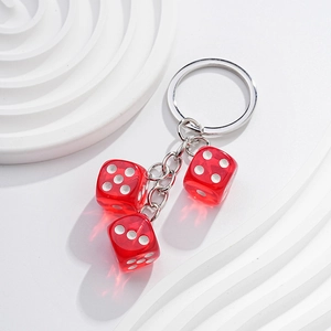 Close-up of three transparent red dice on a silver metal chain for a creative keychain