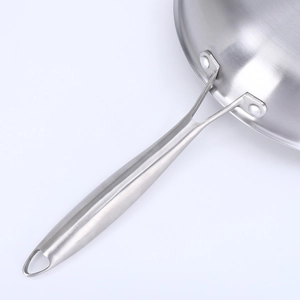 Detail of ergonomic stainless steel handle secured with rivets to the frying pan body