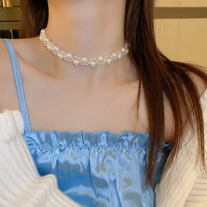 Detail of French vintage necklace with woven faux pearls and transparent crystals on neck