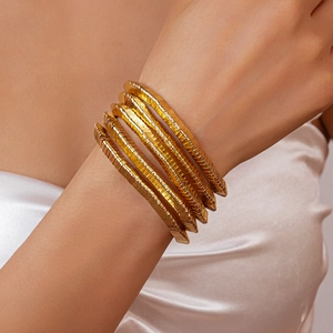Close-up of gold multi-layer wrap bracelet with detailed ribbed texture on the metal