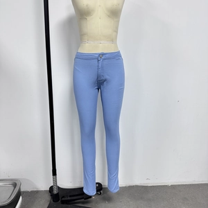 Macro detail of high-waisted light blue slim fit jeans with precise stitching on mannequin