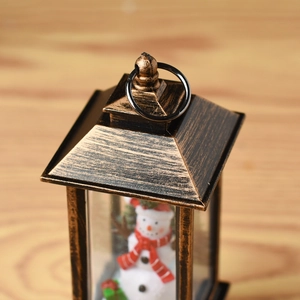 Close-up of vintage bronze Christmas lantern with a snowman figurine and metal ring handle