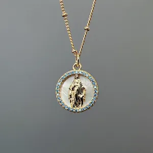 Detail of Virgin Mary relief on white mother-of-pearl pendant with blue zircon frame