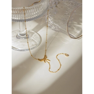 Detailed view of 18k gold plated stainless steel bow pendant with zircon stone drop