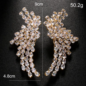Sparkling angel wing earrings with clear zircon stones on gold base, 9cm long