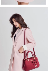 Detail of red leather tote bag with star charm worn with an elegant wool coat