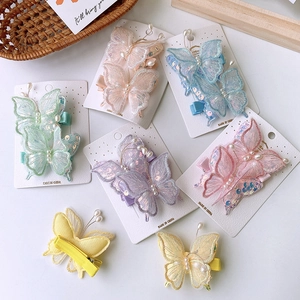 Dettaglio di fermagli per capelli a farfalla colorati con paillettes e perle su card