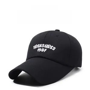 Detail of white 3D embroidered TREASURES 1987 letters on a black cotton baseball cap
