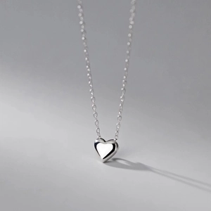 Close-up of heart-shaped zircon pendant with high-polished silver finish and fine chain