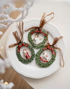 Close-up of three vintage resin Christmas ornaments with Santa and angel on white plate