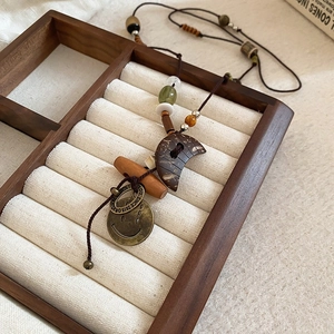 Collier bohème avec lune en bois et pièce en cuivre gravée sur un plateau en velours