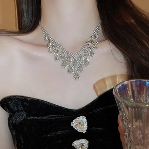 Detailed view of silver rhinestone V-shaped necklace with elegant drop fringe tassels