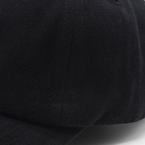 Vue macro détaillée de la texture du sergé de coton noir et des coutures de la casquette
