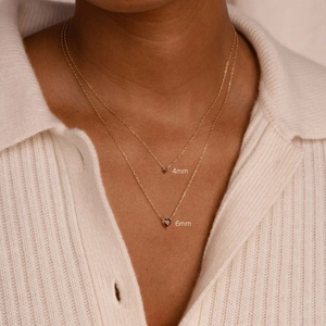 Necklace detail showing size comparison between 4mm and 6mm heart-shaped garnet pendants