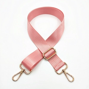 Detail of pink nylon bag strap featuring golden lobster clasps and adjustable buckle