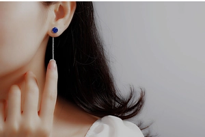 Close-up of S925 sterling silver drop earring featuring a dark blue zircon and fine chain