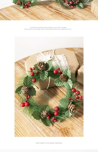 Detailed view of small Christmas wreath with green needles and pinecones on a wooden surface