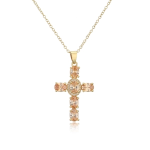 Macro shot of gold-plated cross pendant with oval champagne zircon and halo diamonds