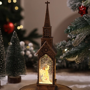 Close-up of a bronze church snow globe lantern with warm LED light and angel inside
