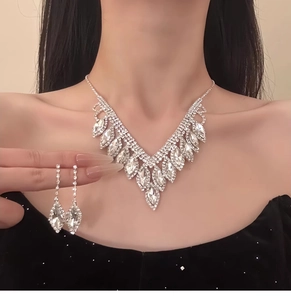 Detail of elegant silver tassel necklace and teardrop earrings with crystals on a model