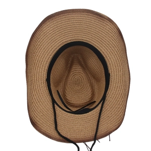Detail view of woven straw hat interior featuring black sweatband and adjustable drawstring