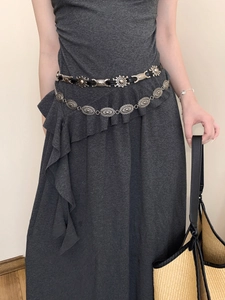 Detail view of retro geometric butterfly chain belt on a slim dark grey knitted dress