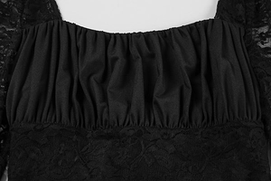Detail of square neckline with lace stitching and pleated texture on slim black dress